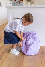 MontiiCo Swaggies Collab Backpack - Cosmic Bloom child placing fusion drink bottle in the side pocket